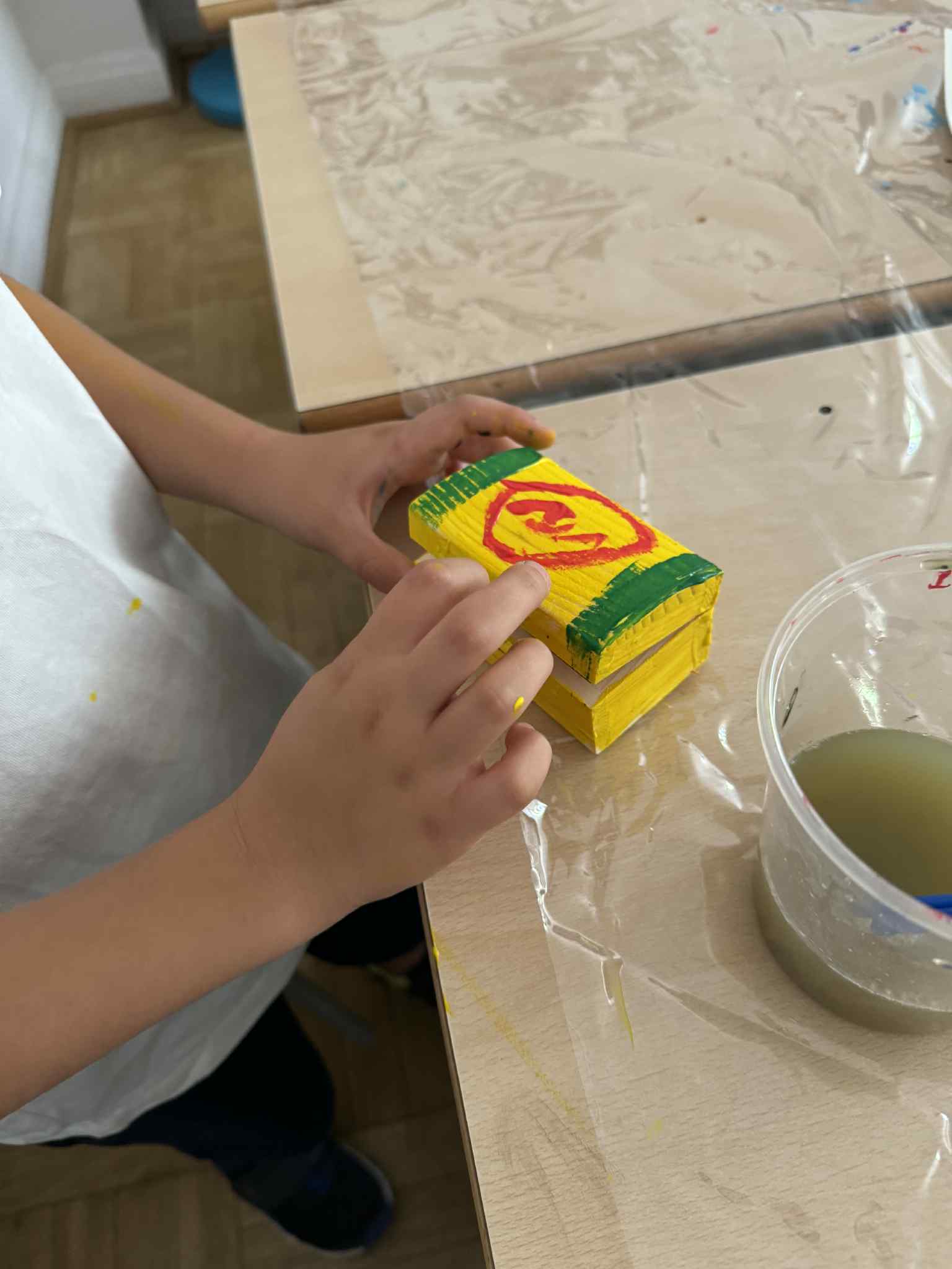 Dziecko maluje żółte pudełko